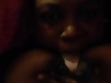 Busty Ebony sucking both her nipples in bed